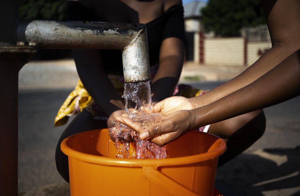mulher-africana-servindo-agua-em-um-recipiente-ao-ar-livre / Foto: Imagem: ilustrativa do Freepik
