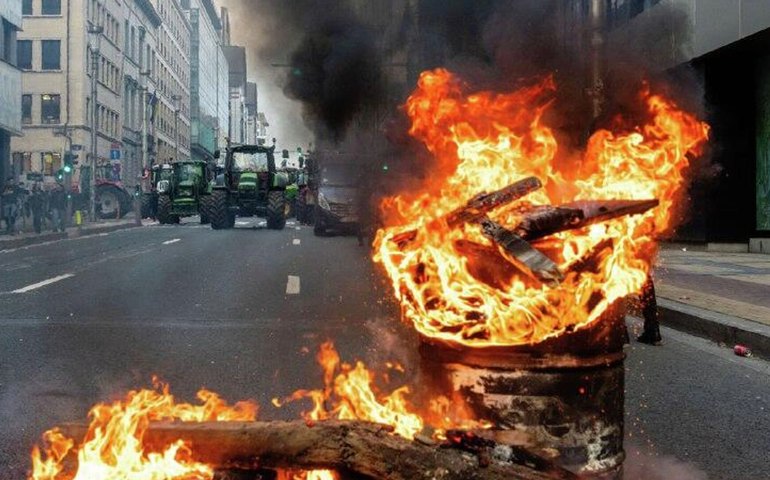 Um barril arde em chamas durante protestos de agricultores em frente ao Parlamento Europeu