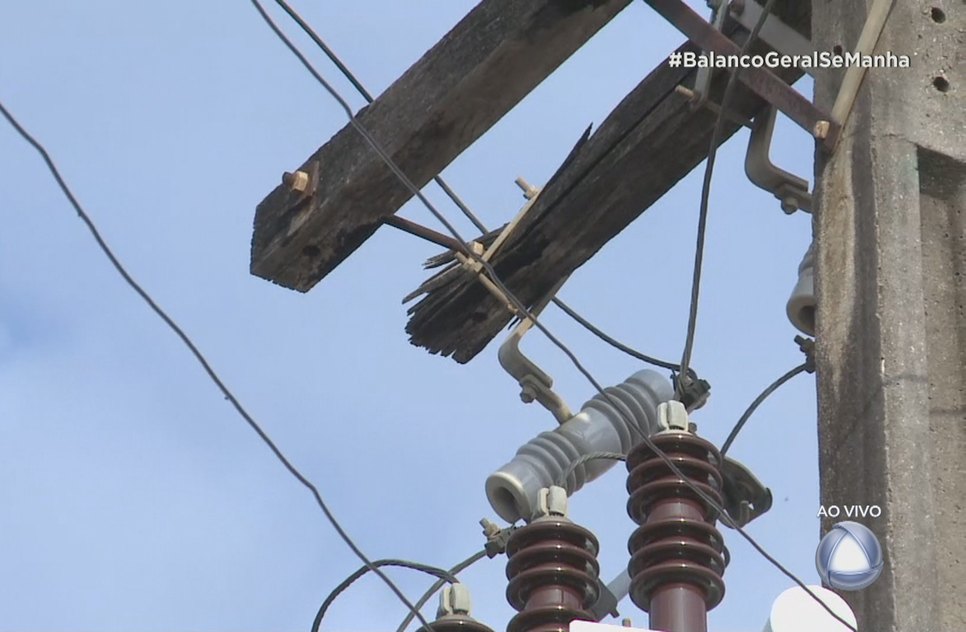 Poste de energia elétrica com base de madeira corre risco de cair 