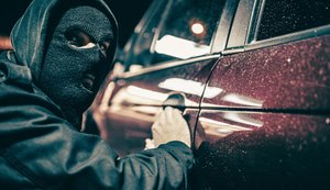 Homem arrombando carro. Imagem ilustrativa