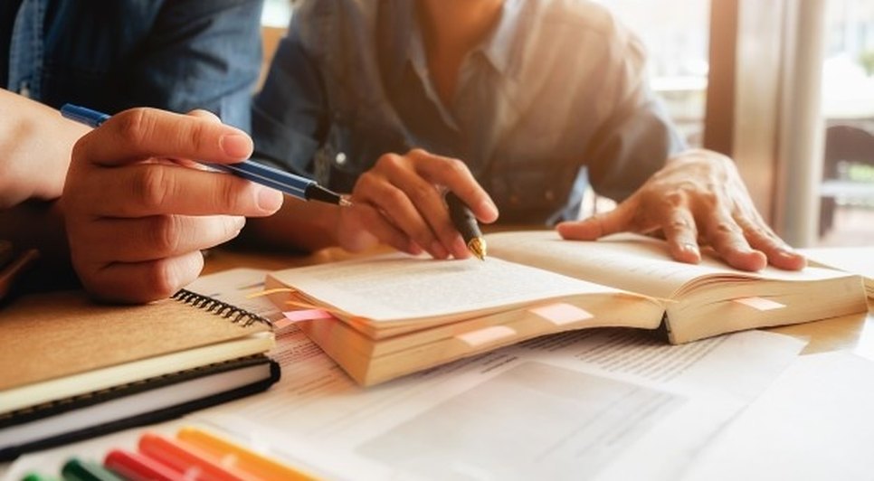 conceito-de-educacao-estudante-estudando-e-brainstorming-conceito-de-campus-perto-de-estudantes-discutindo-seu-assunto-em-livros-ou-livros-didaticos-foco-seletivo_1418-627