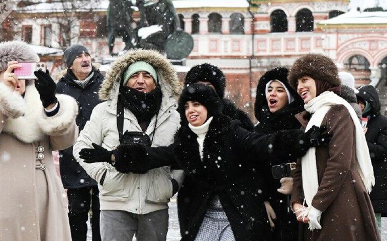 Turistas estrangeiros fazem selfie em meio à neve na Praça Vermelha