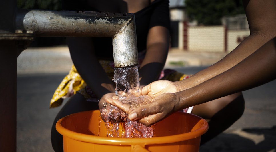 mulher-africana-servindo-agua-em-um-recipiente-ao-ar-livre / Foto: Imagem: ilustrativa do Freepik