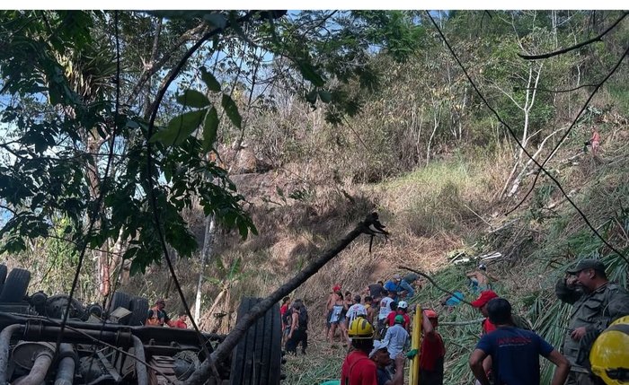 Imagem mostra o ônibus tombado e pessoas se organizando no socorro às vítimas