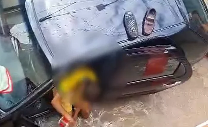 Família tenta salvar carro de alagamento Família tenta salvar carro de alagamento