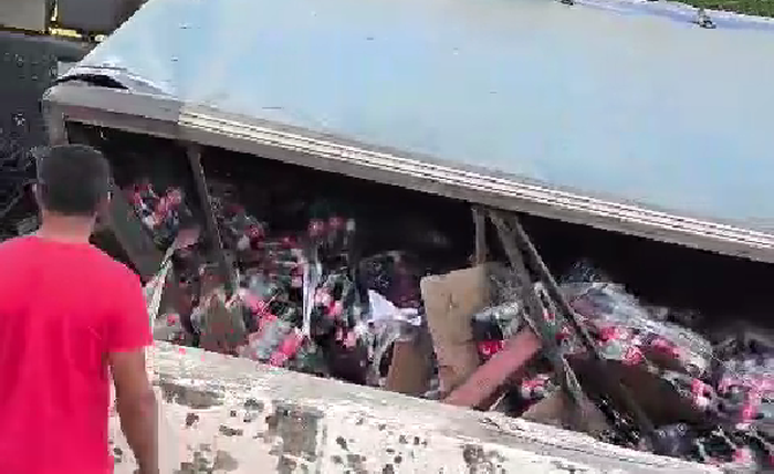 Caminhão com carga de Coca-Cola tombado